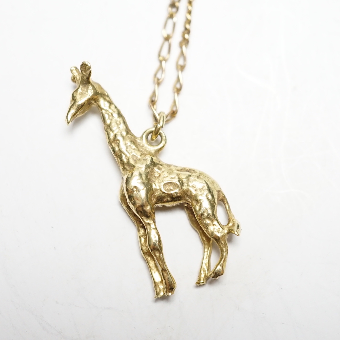 A South African yellow metal giraffe pendant, 30mm, on a 9k chain, gross weight 7.4 grams.